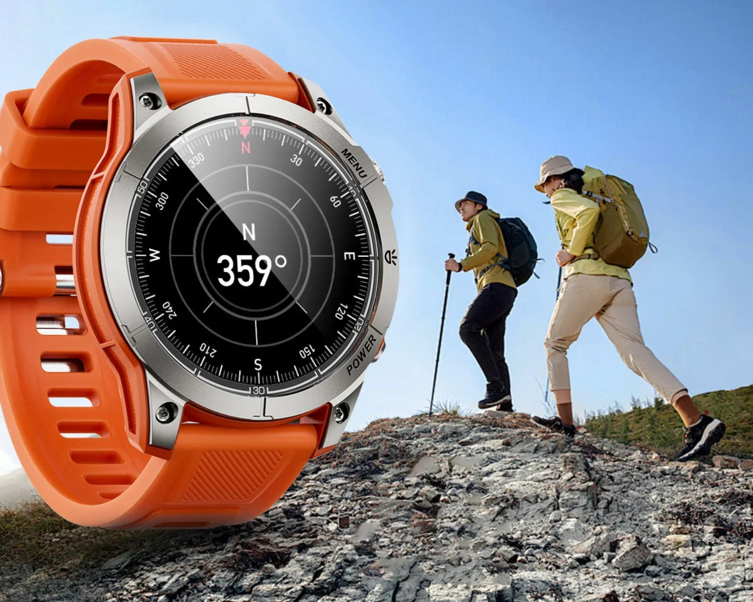 Orange outdoor sports watch displaying compass reading near two hikers climbing rocky hill under clear sky